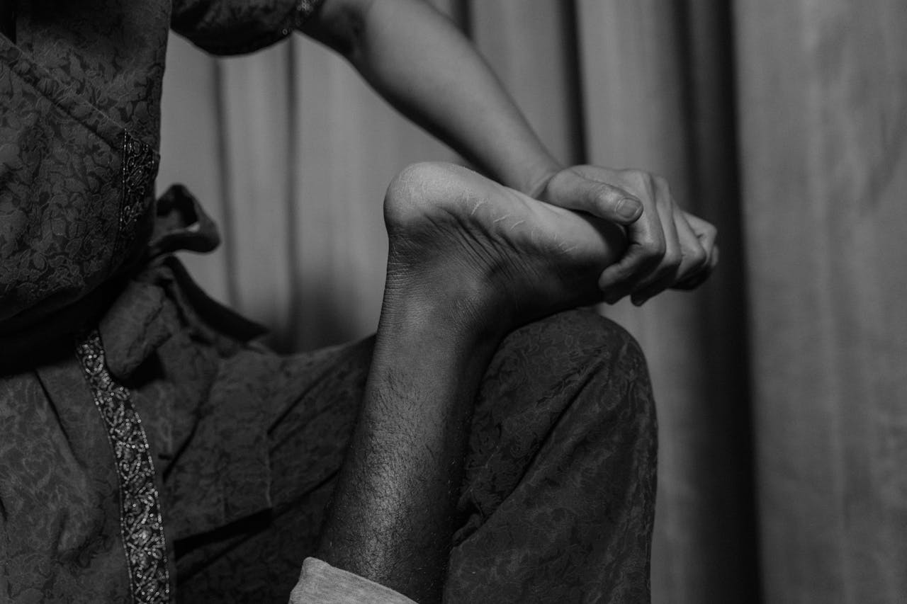 Black and white close-up of a foot massage, emphasizing relaxation and wellness.